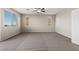 Spacious bedroom featuring plush gray carpet, large windows, and a ceiling fan at 7364 Marbury St, Las Vegas, NV 89166