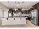 Gourmet kitchen with granite counters, stainless appliances, dark wood cabinets, and a large island at 7364 Marbury St, Las Vegas, NV 89166