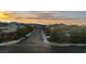 A tranquil street view captures houses set against a sunset sky, showcasing a peaceful and picturesque neighborhood at 7364 Marbury St, Las Vegas, NV 89166