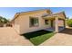 Home's backyard showcasing the rock landscaping, artificial turf, and stucco exterior at 768 Flowing Meadow Dr, Henderson, NV 89014