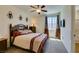 Comfortable bedroom with a ceiling fan, complementary red pillows and a decorative headboard at 768 Flowing Meadow Dr, Henderson, NV 89014