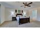 Well-lit bedroom featuring a ceiling fan, carpeted floors and a private bath at 768 Flowing Meadow Dr, Henderson, NV 89014
