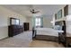 Spacious bedroom with carpeted floors, ceiling fan, and windows overlooking the landscape at 768 Flowing Meadow Dr, Henderson, NV 89014