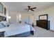 Well-lit bedroom featuring a ceiling fan, carpeted floors and a private bath with dual doors at 768 Flowing Meadow Dr, Henderson, NV 89014