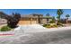 Single-story home featuring a well-manicured lawn, desert landscaping, and a three-car garage at 768 Flowing Meadow Dr, Henderson, NV 89014