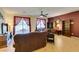 Bright living room featuring leather sofas, a ceiling fan, and a view of the outdoor scenery through large windows at 768 Flowing Meadow Dr, Henderson, NV 89014