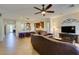 Living room with a seamless flow to the kitchen, featuring a ceiling fan, tile flooring, and a view of the kitchen bar at 768 Flowing Meadow Dr, Henderson, NV 89014