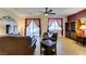 Well-lit living room with cozy leather furniture, a ceiling fan, and sliding glass doors leading to the outdoors at 768 Flowing Meadow Dr, Henderson, NV 89014