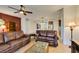 Expansive living area with leather sofas, tile floors, and a view through an archway to the kitchen's granite countertop bar at 768 Flowing Meadow Dr, Henderson, NV 89014