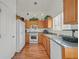 Well-lit kitchen with wooden cabinets, white appliances, and hardwood floors, offering a functional space at 851 Offerman Ave, Las Vegas, NV 89123