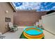 Backyard patio with comfortable seating around an inflatable pool, and a brick privacy wall at 9431 Borough Park St, Las Vegas, NV 89178