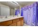 Bathroom features a double sink vanity, a large mirror, and a shower/tub combo at 9431 Borough Park St, Las Vegas, NV 89178