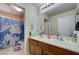 Bright bathroom featuring a double sink vanity and a shower/tub combo with themed curtains at 9431 Borough Park St, Las Vegas, NV 89178