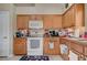 Functional kitchen with light wood cabinetry, neutral countertops, and essential appliances at 9431 Borough Park St, Las Vegas, NV 89178