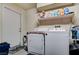Functional laundry room with a white washer and dryer set, complemented by shelving and ample storage space at 9431 Borough Park St, Las Vegas, NV 89178