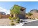 Two-story home with desert landscaping, a two-car garage, and a mix of stone and stucco finishes at 9641 Rankin Ridge Ct, Las Vegas, NV 89178