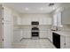 Bright kitchen features white cabinets, stainless steel appliances, and tiled floors at 1012 Vanier Ct, Henderson, NV 89052