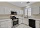 Bright kitchen features white cabinets, stainless steel appliances, and tiled floors at 1012 Vanier Ct, Henderson, NV 89052
