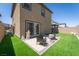 Inviting backyard with artificial grass, a cozy seating area, and low-maintenance landscaping, perfect for entertaining at 10352 Rye Patch Creek St, Las Vegas, NV 89141