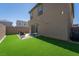 Backyard with artificial turf, a small patio area, and privacy fencing, perfect for outdoor relaxation at 10352 Rye Patch Creek St, Las Vegas, NV 89141