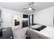 Well-lit bedroom with a ceiling fan, flat-screen TV, and a modern black desk at 10352 Rye Patch Creek St, Las Vegas, NV 89141