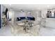 Open concept living space with dining area featuring a glass table and kitchen with white countertop and stainless steel appliances at 10352 Rye Patch Creek St, Las Vegas, NV 89141