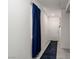 Clean hallway with neutral walls, tile floors, a white door and a pop of color from blue curtains at 10352 Rye Patch Creek St, Las Vegas, NV 89141