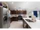 Well-equipped kitchen featuring dark wood cabinetry, stainless steel appliances, and a light countertop at 10352 Rye Patch Creek St, Las Vegas, NV 89141