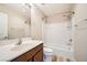 Bathroom with a tub and shower combination and vanity with a sink and dark wood cabinet at 10513 Bandera Mountain Ln, Las Vegas, NV 89166