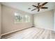 Bright bedroom featuring two windows for natural light and light wood flooring at 10513 Bandera Mountain Ln, Las Vegas, NV 89166