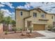 Charming exterior view showcasing desert landscaping, a two-car garage, and a warm neutral color scheme at 10513 Bandera Mountain Ln, Las Vegas, NV 89166