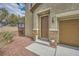 Inviting entryway with a brown front door, stone accents, and desert-style landscaping with welcoming decor at 10513 Bandera Mountain Ln, Las Vegas, NV 89166