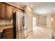 Well-appointed kitchen featuring stainless steel appliances, wood cabinetry, and open layout, connecting to the dining area at 10513 Bandera Mountain Ln, Las Vegas, NV 89166