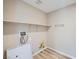 A well lit laundry room with wood-look flooring, a shelf, and hookups for the machines at 10513 Bandera Mountain Ln, Las Vegas, NV 89166