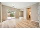 Open living room with sliding glass doors leading to a fenced backyard and light wood flooring throughout at 10513 Bandera Mountain Ln, Las Vegas, NV 89166