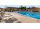 A refreshing swimming pool features rows of lounge chairs and shade structures at 10513 Bandera Mountain Ln, Las Vegas, NV 89166