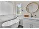 Bright bathroom featuring a soaking tub, marble accents, and a stylish round mirror, creating a spa-like atmosphere at 10613 Turquoise Valley Dr, Las Vegas, NV 89144