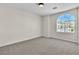 Bedroom with carpet flooring and an arched window overlooking neighborhood at 10613 Turquoise Valley Dr, Las Vegas, NV 89144