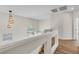 Bright staircase features chandelier, white railing, and view of the backyard pool at 10613 Turquoise Valley Dr, Las Vegas, NV 89144