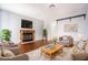Cozy living room with a rustic fireplace, plush seating, and warm, neutral tones at 110 Wynntry Dr, Henderson, NV 89074