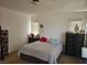 Bright bedroom is shown with striped bedding, side tables, and two large windows at 1169 Paradise River Rd, Henderson, NV 89002
