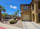 Tan two-story home with desert landscaping and a one-car garage, perfect for a small Gathering at 1169 Paradise River Rd, Henderson, NV 89002