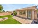 Private backyard with brick patio, well-manicured green grass, mature trees, and retaining wall at 11764 Golden Moments Ave, Las Vegas, NV 89138