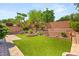 Expansive backyard features lush green turf, tiered retaining walls, and a charming stone fire pit at 11764 Golden Moments Ave, Las Vegas, NV 89138