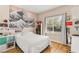 Bright bedroom with unique wall art, wood-look flooring, and natural light from large window at 11764 Golden Moments Ave, Las Vegas, NV 89138