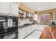 Close up of kitchen featuring white cabinets, black countertops, and stainless steel appliances at 11764 Golden Moments Ave, Las Vegas, NV 89138