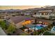 Aerial view of backyard with pool, spa, outdoor kitchen, and lush landscaping at sunset at 11954 Camden Ridge Ct, Las Vegas, NV 89138