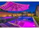 Inviting backyard with pool, spa, sun loungers, and an outdoor kitchen illuminated at dusk at 11954 Camden Ridge Ct, Las Vegas, NV 89138