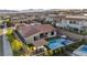 Aerial view of a backyard featuring a pool with an integrated spa, covered outdoor kitchen, and manicured landscaping at 11954 Camden Ridge Ct, Las Vegas, NV 89138