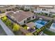 Aerial view of a backyard featuring a pool with an integrated spa, covered outdoor kitchen, and manicured landscaping at 11954 Camden Ridge Ct, Las Vegas, NV 89138